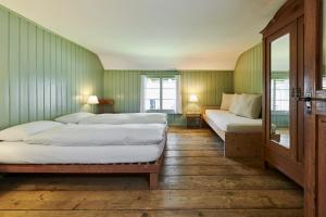 a room with four beds in a room with green walls at Fischerhäuser Romanshorn in Romanshorn
