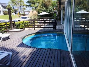 a swimming pool on a deck with a house at Departamentos Punta Pampa in Las Gaviotas