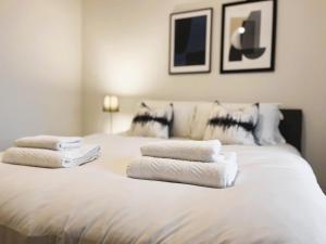 a white bed with towels on top of it at Brand new modern 1 bed apartment near Old Trafford Stadium in Manchester