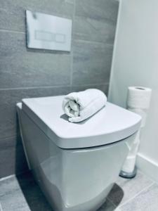 a white toilet in a bathroom with a towel on it at Brand new modern 1 bed apartment near Old Trafford Stadium in Manchester