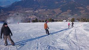 a group of people skiing down a snow covered slope at B&B Casa Riz in Castello di Fiemme