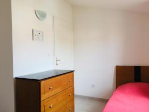 une chambre avec une commode en bois et un lit dans l'établissement Résidence A NUCIOLA Les pieds dans l'eau Cervione Hte CORSE, à Cervione 25 autres photos