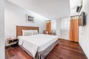 1 dormitorio con 1 cama blanca grande y suelo de madera en P2 Boutique, en Bangkok