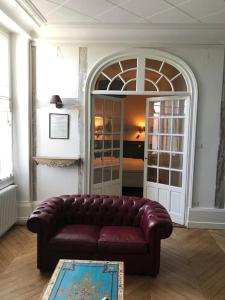 a living room with a brown leather couch in a room at Nid douillet bord de Loire in Blois