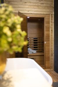 a bathroom with a wooden closet with a sink at Vakantiehuisje Jipué met sauna en bubbelbad. in Bruchterveld