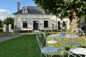 a table and chairs in front of a house at La Folie Saint Julien in Saint-Julien-de-Chédon