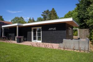 a black building with the word unique on it at Vakantiehuisje Jipué met sauna en bubbelbad. in Bruchterveld