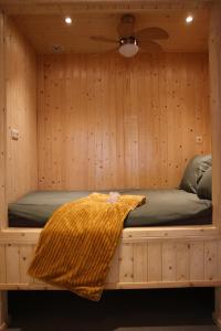 a bed in a sauna with a blanket on it at Vakantiehuisje Jipué met sauna en bubbelbad. in Bruchterveld