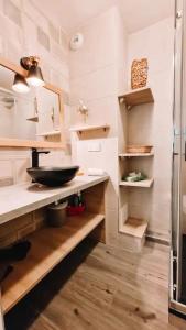 eine Küche mit einem Waschbecken und Holzregalen in der Unterkunft T3 refait à neuf /Plage/Centre/Gare/Terrasse/Pkg/wifi in Arcachon