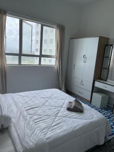 ein Schlafzimmer mit einem weißen Bett und einem großen Fenster in der Unterkunft Eli Homestay in Kuala Terengganu