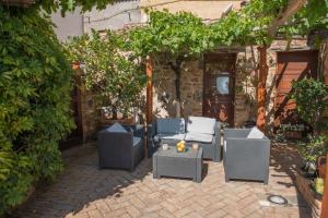 a patio with chairs and a table and trees at Beautiful house in Orosei in Orosei