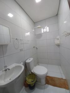 Baño blanco con aseo y lavamanos en Aconchego em Maragogi, en Maragogi