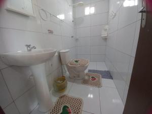 Baño blanco con lavabo y aseo en Aconchego em Maragogi, en Maragogi