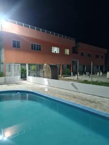 una piscina frente a un edificio por la noche en Aconchego em Maragogi, en Maragogi