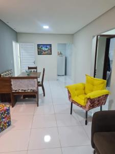 sala de estar con sofá amarillo y mesa en Aconchego em Maragogi, en Maragogi