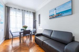 a living room with a black couch and a table at Nice Central Art Deco Flat 45 m² in Nice