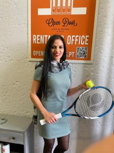 ポンタ・デルガダにあるOpen Door Loftのテニスボールとラケットを持つ女