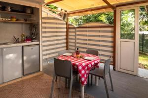 patio con mesa y sillas y cocina en Ti colibri en Les Trois-Îlets