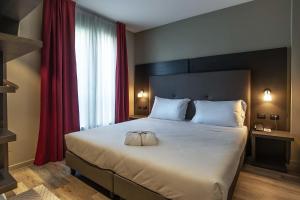 a bedroom with a large white bed with red curtains at Maranello Palace in Maranello