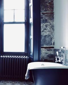 baño con bañera junto a una ventana en Suie Hunting Lodge en Killin