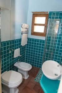 a bathroom with two toilets and a sink and a window at Beautiful house in Orosei in Orosei