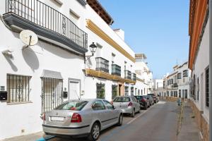 uma fila de carros estacionados numa rua com edifícios em Loft Centro Historico Barbate em Barbate