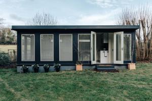 a black and white tiny house in a yard at Cuckoo’s Hideaway in Buckinghamshire