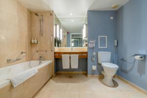 a bathroom with a tub and a toilet and a sink at Holiday Inn Nice - Port St Laurent, an IHG Hotel in Saint-Laurent-du-Var