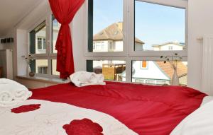 ヘリングスドルフにあるFerienwohnung Lottiのベッドルーム1室(赤と白のベッド1台、窓付)
