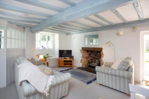 sala de estar con 2 sillas y chimenea en Fox Cottage, en Sidbury