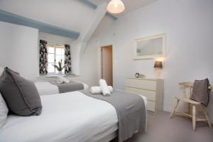 a bedroom with two beds and a table and a chair at Fox Cottage in Sidbury