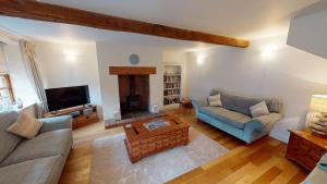 a living room with a couch and a tv at Stables Barn in East Budleigh