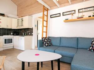 a living room with a blue couch and a table at 4 person holiday home in r sk bing in Ærøskøbing