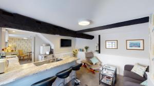 ein Wohnzimmer mit einer Küche und ein Wohnzimmer mit einer Theke in der Unterkunft Cider Cottage in Sidmouth