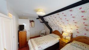 a bedroom with a bed and a wall with flowers at Cider Cottage in Sidmouth +10 photos