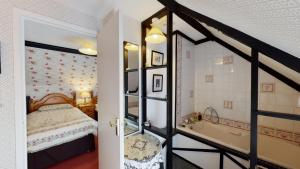 Schlafzimmer mit einem Bett und einer Badewanne in der Unterkunft Cider Cottage in Sidmouth