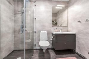 a bathroom with a shower and a toilet and a sink at Flygeln in Leksand