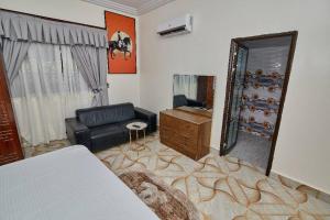 sala de estar con espejo y sofá en POMAA VILLA, en Kumasi