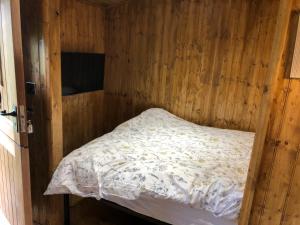 a bedroom with a bed in a wooden wall at Goodwin Farm in Northiam