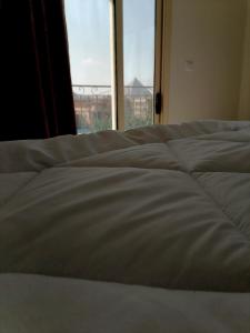 a bed in a room with a large window at primo pyramids inn in Cairo