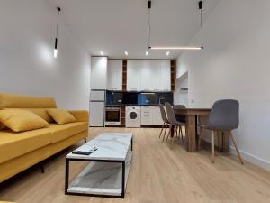 a living room with a yellow couch and a table at Luxury apartments Blloku in Tirana