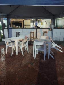 a group of white tables and chairs under a tent at Pousada Praia Grande - Rua Ernesto Vergara ,511 in Praia Grande