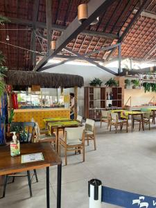 a restaurant with tables and chairs and people in the background at Hotel Village Porto de Galinhas - Apartamento 215 in Porto De Galinhas