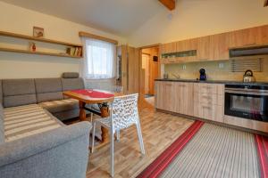 a kitchen and living room with a table and a couch at Domeček VALERIE in Velké Losiny