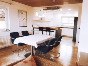 ein Esszimmer mit einem weißen Tisch und Stühlen in der Unterkunft Apartmenthaus Schöne Aussicht in Bräunlingen