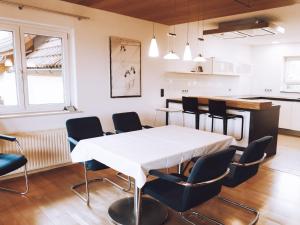 ein Esszimmer mit einem weißen Tisch und Stühlen in der Unterkunft Apartmenthaus Schöne Aussicht in Bräunlingen