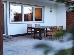 einen Holztisch und Stühle auf einer Terrasse in der Unterkunft Apartmenthaus Schöne Aussicht in Bräunlingen