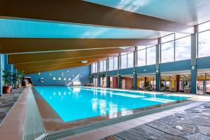 a large swimming pool in a building with windows at Eurostrand Resort Moseltal in Leiwen