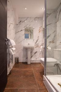 a bathroom with a sink and a toilet and a mirror at The Castle Collection 14 Cook Street in Liverpool