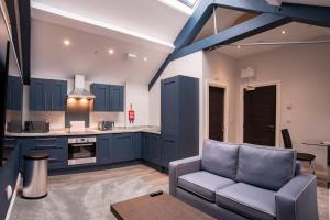 a kitchen with blue cabinets and a couch at The Castle Collection 14 Cook Street in Liverpool